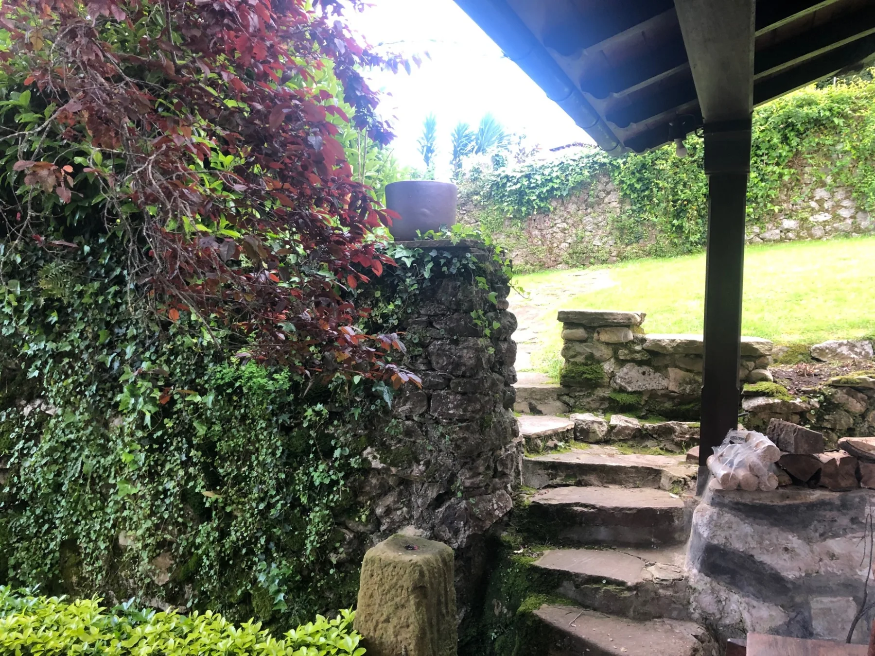 Porche de piedra con escaleras y jardín
