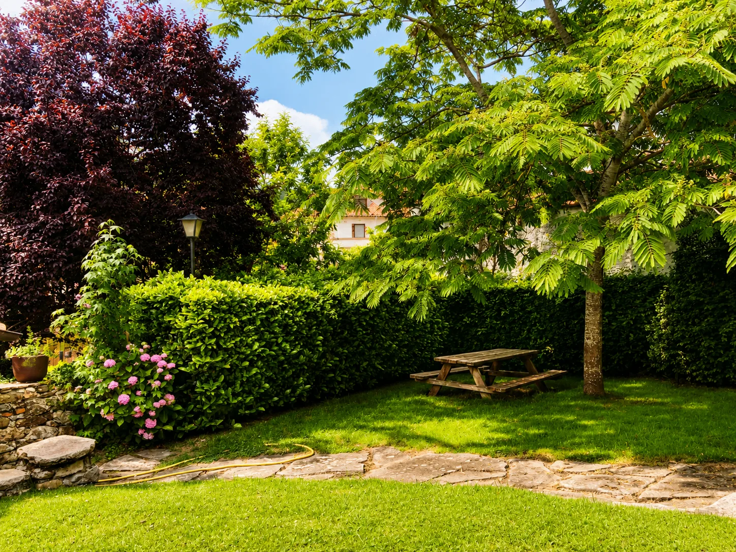 Jardín con cerezo y mesa de picnic
