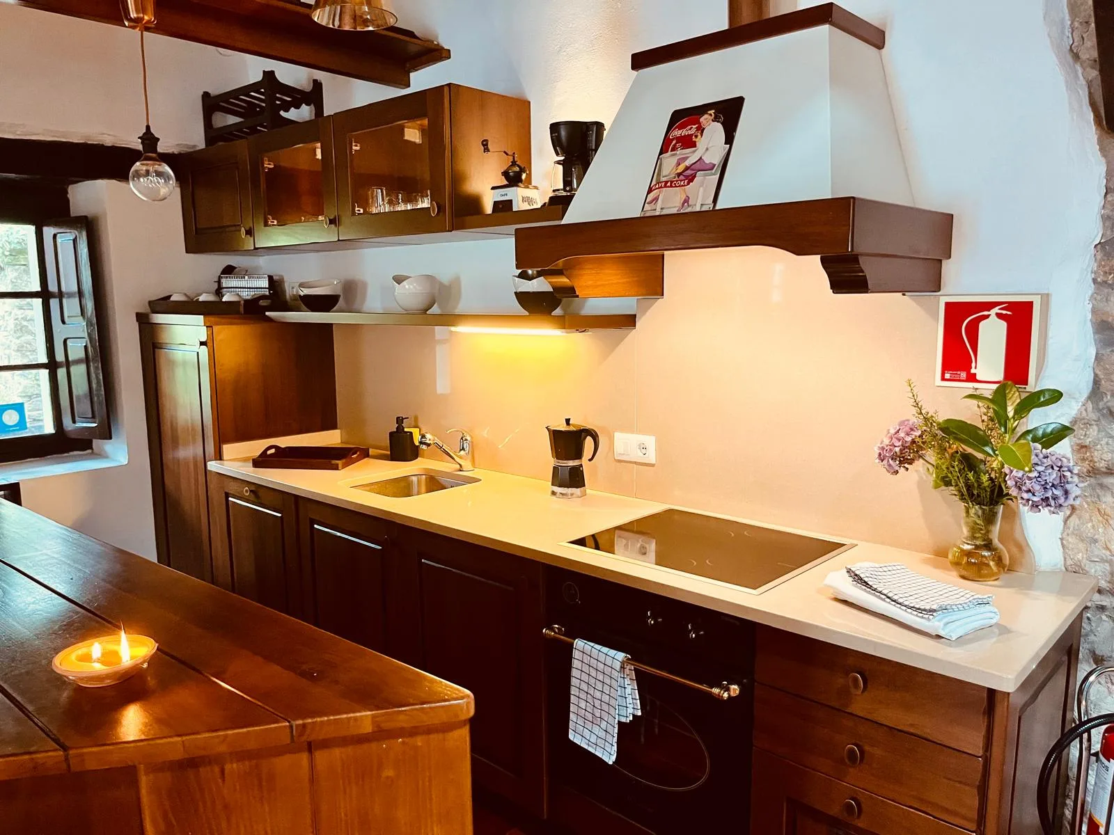 Cocina equipada con vitrocerámica y campana de madera
